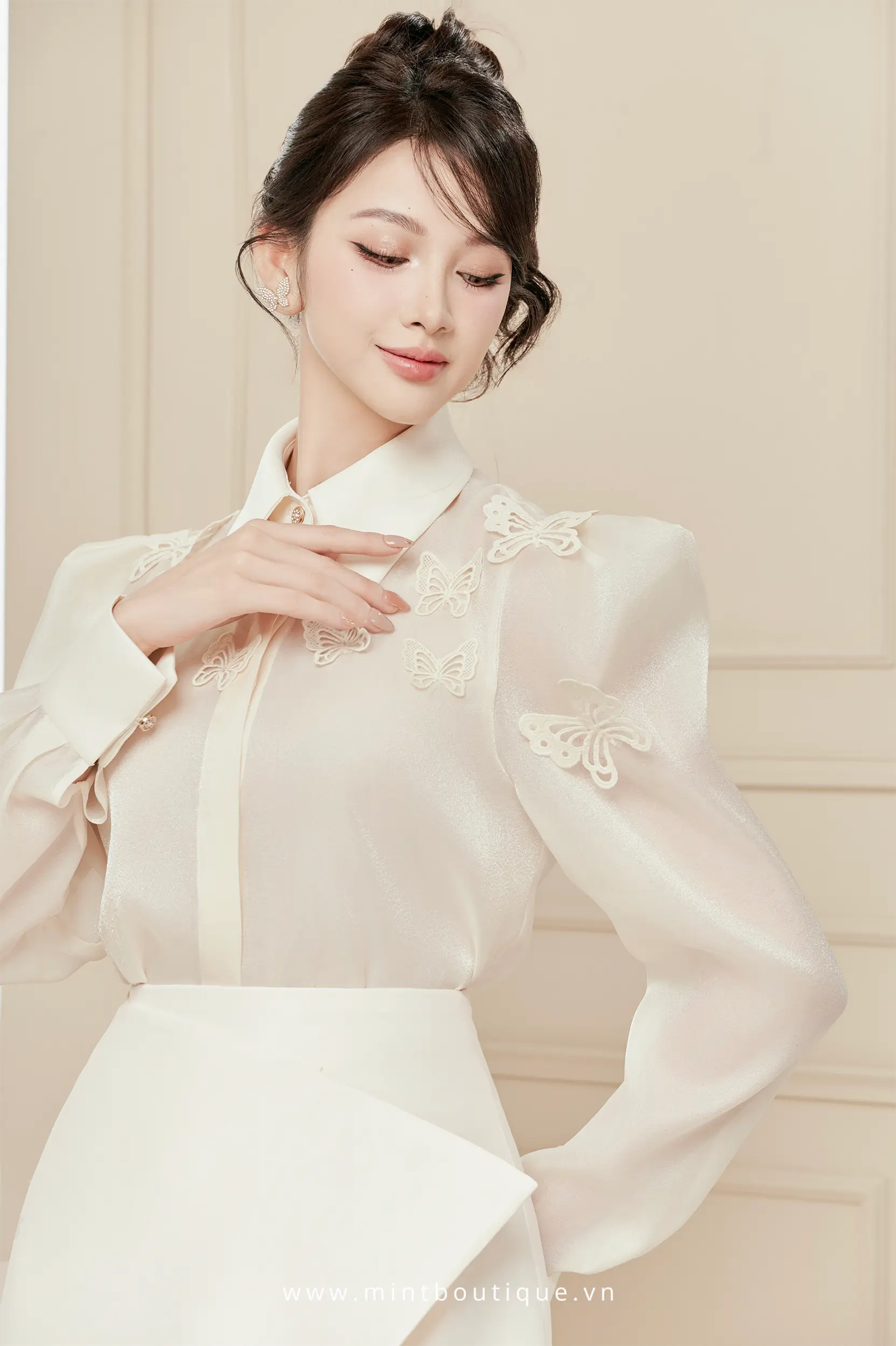 Áo sơ mi tơ óng kem cổ đức đính bướm trên vai
